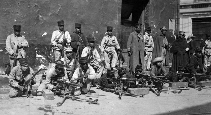 SOLDADOS DESCANSAN EN BANQUETA DURANTE LOS COMBATES DE LA DECENA TRÁGICA. FOTO SINAFO.FN.INAH.jpg