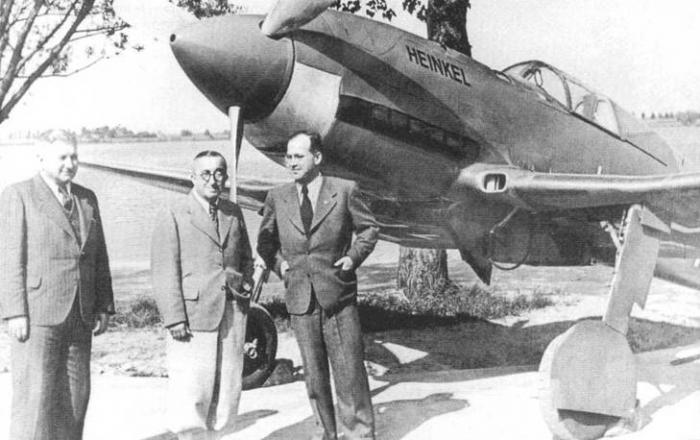 Директор фирмы Hienkel – Карл Хаун, Эрнст Хейнкель, а также Роберт Луссер, за ними прототип – He-100 V7.