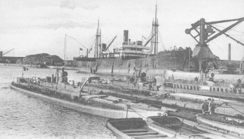Кастор и две однотипные подводные лодки стоящие во французском порту перед отправкой на Дальний Восток, на борту уникального корабля-дока «Фудр», который был специально перестроен для транспортировки подводных лодок, более крупных чем миноносцы которые он обычно перевозил.