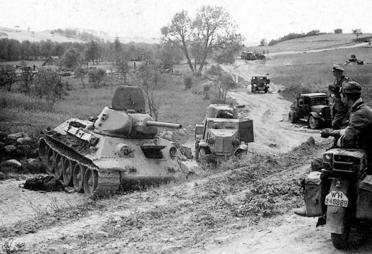 Дорога отступления. Брошенные без видимых повреждений, скорее всего по причине отсутствия топлива, танк Т-34, бронеавтомобиль БА-10 и грузовики ЗИС-5. Лето 1941 года.