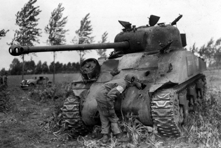 Десантник 101-й дивизии США осматривает пробоины в лобовом листе подбитого британского танка «Шерман Файрфлай»