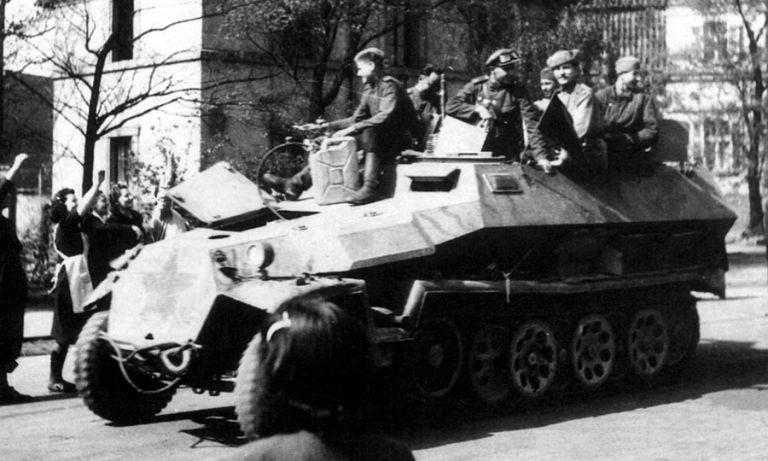 Красноармейцы на броне трофейного немецкого бронетранспортёра Sd.Kfz. 251 на улице одного из европейских городов. Во избежание «дружественного огня» во весь лобовой лист брони нанесена красная звезда