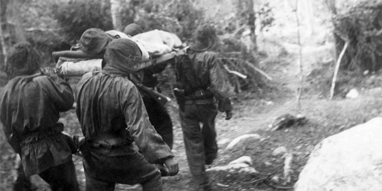 Немецкие солдаты из 6-й горной дивизии СС «Норд» переносят раненого