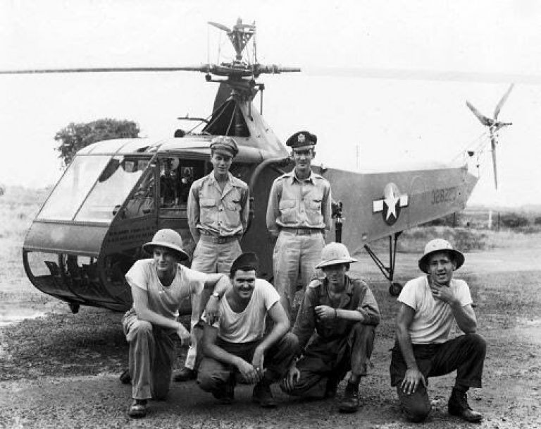 Фотография из Музея ВВС США сделанная, вероятно, в январе 1945 года. Летенант Картер Харман (стоит справа) Слева стоит Фрэнк Петерсон, ветеран-испытатель вертолёта Р4, который выполнит одну из первых спасательных операций. На фоне — Сикорский Р4.