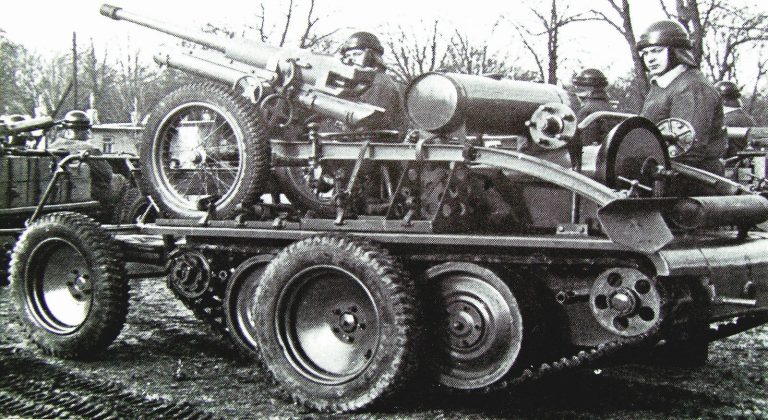 Тележка ADMK с приподнятым гусеничным движителем и приспущенными катками для доставки противотанковой пушки. 1937 год