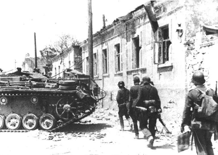 Немецкие солдаты проходят по улице мимо САУ StuG III. Окраины Севастополя, 1942 год Источник – waralbum.ru