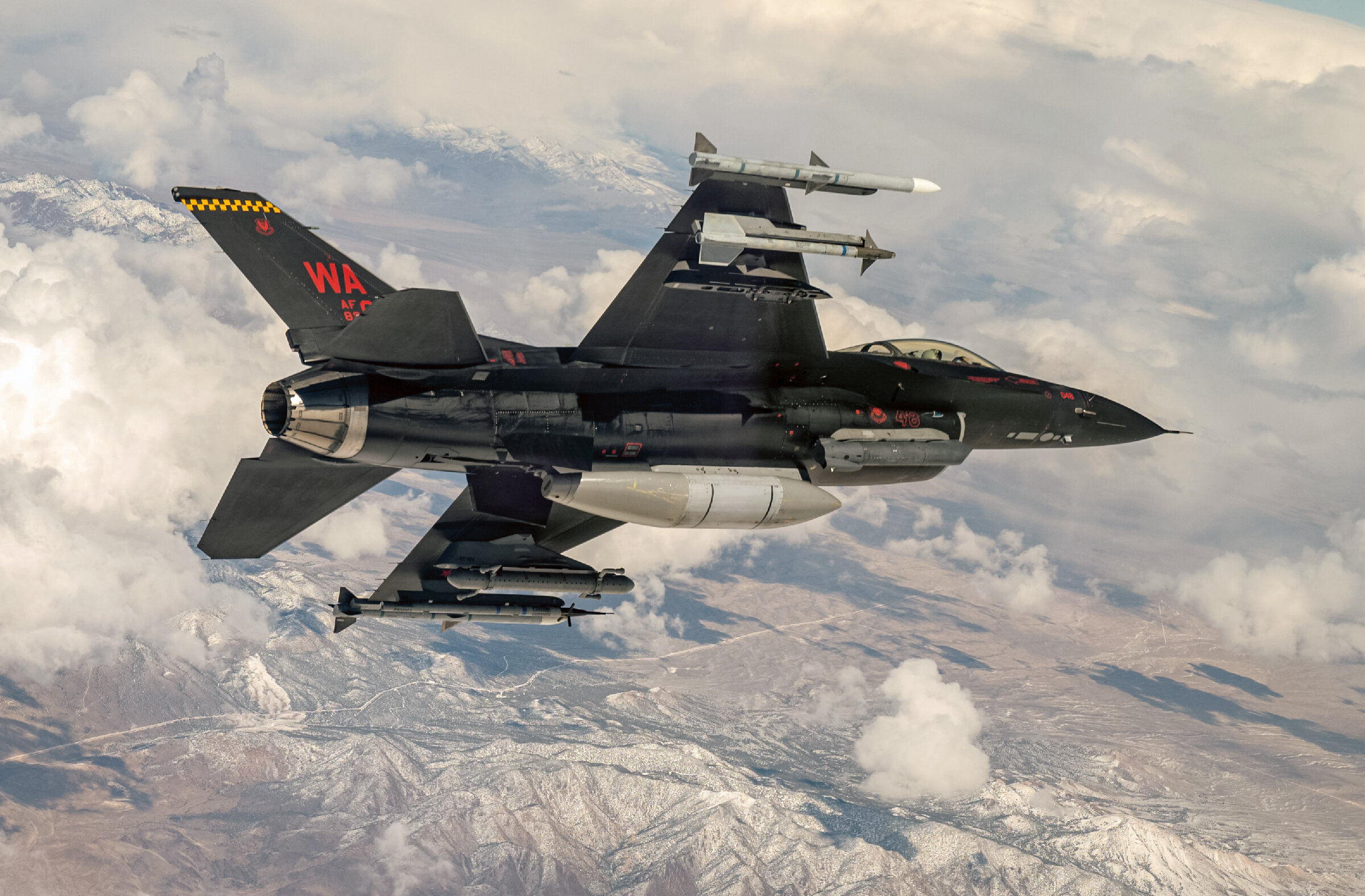 F-16C блок 42 с/н 89-2048 из 64-й эскадрильи "агрессор"; единственный F-16, полностью окрашенный в черный цвет. Авиабаза Нэллис, 2023 г. Контейнер AN/ALQ-167 подвешен под левой плоскостью крыла.