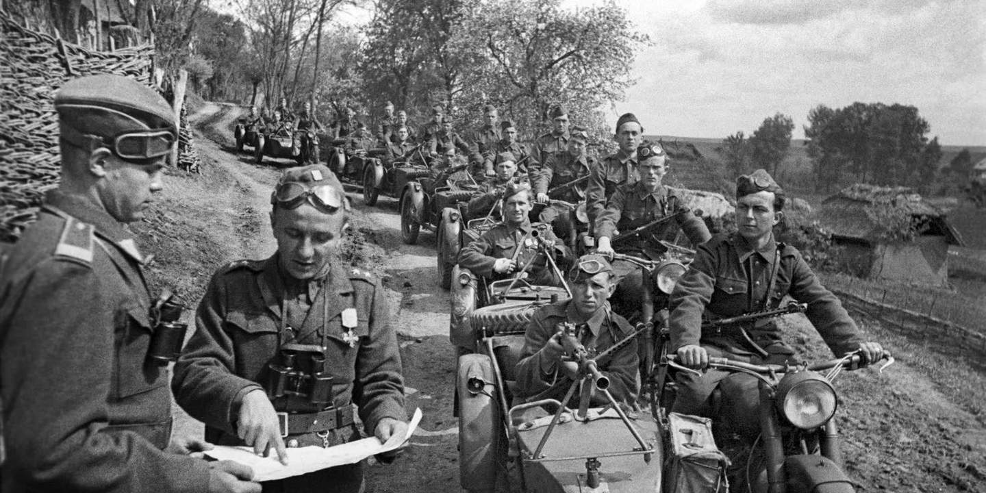 Мотоциклисты на мотоциклах М-72 советского 1-го чехословацкого корпуса на улице деревни в Карпатах