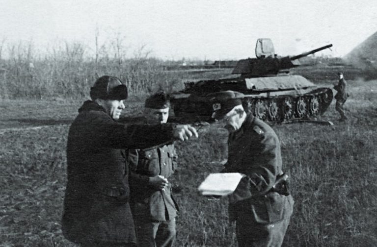 Фашисты спрашивают у местного жителя дорогу на фоне трофейного Т-34-76, 1941 г.